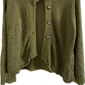 Stickad kofta - Stickad grön kofta med vida ärmar, 70% bomull 30% nylon. Fint skick! Garnet har lite glitterdetaljer