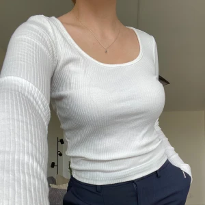 Vit långärmad tröja  - Simpel långärmad ribbad tröja. Skön och stretchig material. 