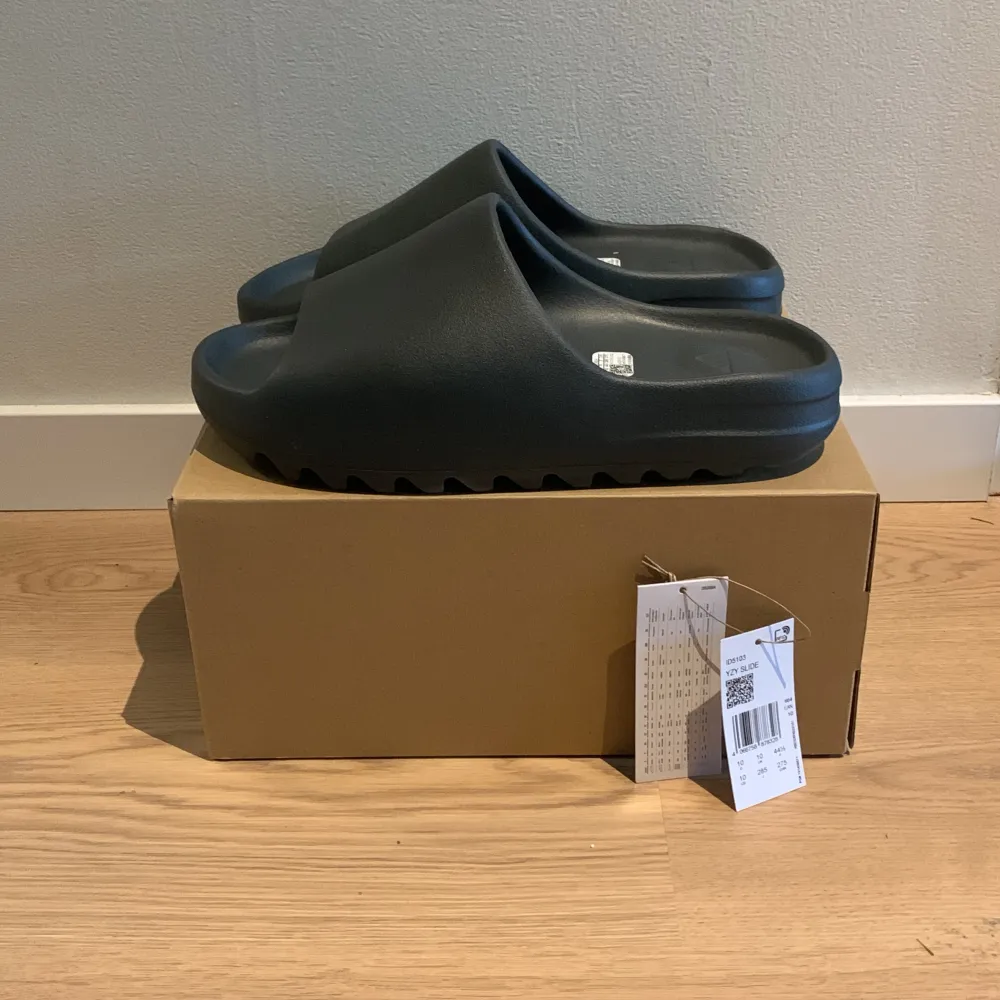 Säljer ett par yeezy slides i colorwayen  Dark Onyx ⚫️👟De är helt nya i st 44,5  Köptes feån adidas CONFIRMED, kvitto finns🧾✅ Bara att höra av sig om man har några frågor😀🔥🍀. Skor.