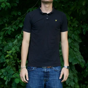 Svart Lyle & Scott Piké - Modellen är 180cm