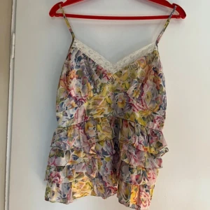 Spets linne med volanger - Super gulligt spets linne med blommor och volanger!