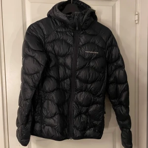 Peak Performance Jacka - Tunn dunjacka från peak i modell helium, den glansigare färgen. Bra skick förutom en reva i ärmen som är tejpad. 