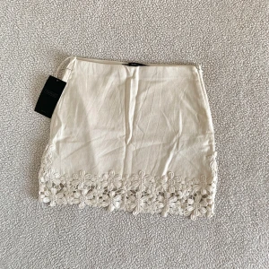 ZARA krämvit minikjol med virkad spets - Otroligt vacker krämvit kjol från ZARA med virkad spetskant. Ny med tags kvar, utan anmärkningar.