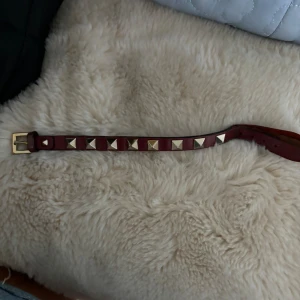 Valentino armband - Deffekt bild 2, somsagt lite sönder går säkert att limma men man kan fortfarande sätta på sig armbandet. Priset är pga defekterna! Vinrött.