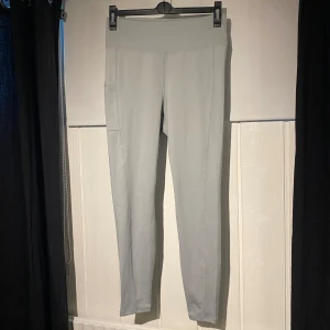 Träningstights - Ljusblå/grå träningstights med en ficka på ena låret, helt oanvända