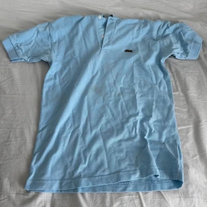 Lacoste polo shirt - Hej säljer min Lacoste polo tröja. Nypris ligger på ca 1200. Den är i bra skick material mässigt men är väldigt skrynklig och har en stor fläck smutts. Det går såklart att fixa. Säljer för 140kr. Skriv om frågor