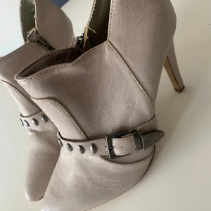 Höga halvboots  - Super snygga halv boots, creme färgade med hög klack och dekorativa nitar.