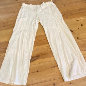 Lågmidjade linnebyxor - Linnebyxor i bra skick, jag har sytt in dem lite vid midjan men det går lätt att sprätta bort! Vita och vida.storleken står inte men jag skulle tippa på storlek 42+