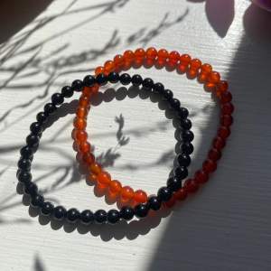 Två Brandy Melville armband i genomskinligt orange och helt svart. Oanvända, nyskick 