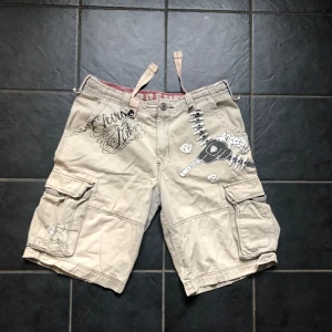 Superfeta ed hardy likande shorts - Feta beigea shorts Finns några skrapor på fickorna men inga grova hål eller skador Lägger sig rakt under knän på mig (168 cm) Pris kan diskuteras🙀