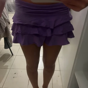 Lila volang kjol - Säljer denna så söta lila mini volang kjol! Går att ha både lågmidjad och vanligt, perfekt till utgång eller temafest. Den e egentligen från barnavdelningen men passar mig som brukar ha XS❣️