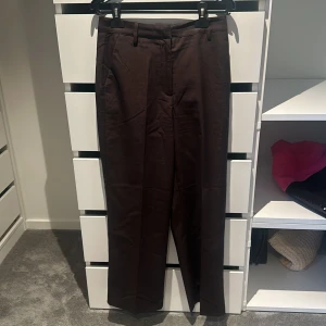 Brun kostymbyxa - Bruna raka kostymbyxor från bikbok, aldrig använda så jätte fint skick, storlek 38