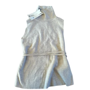 Zara topp - Stickad ärmlös zara topp med polo krage och band rund midjan! Beige vit typ? Helt ny med prislappen kvar, köpt förra året men hann inte lämna tillbaks. Bild 1 är lånad på samma för o visa passformen💋 nypris 379kr