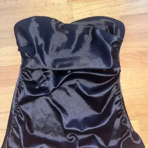 En svart tub topp i silkes material, storlek s 