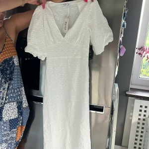Vit klänning/ studentklänning - En sprillans ny midiklänning med blommönster från NAKD. Perfekt till studenten och andra sommarevenemang !!  ☀️Säljer eftersom jag har hittat en annan! Klänningen är köpt för 799kr!