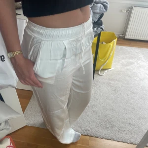 Sidenbyxor  - Vita raka sidenbyxor i super bra skick!! Bra kvalité då det är ett tjockare sidentyg. Säljer då de är för små för mig. Står m i byxorna men de är små i storleken så skulle säga S. Går ner till fötterna på mig som är 170