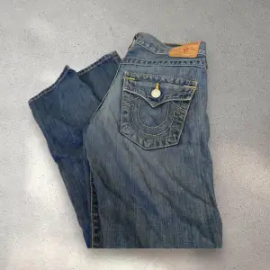 Säljer ett par as snygga True Religion jeans som är raka och lågmidjade! Dom är strl 24 och lite för små för mig så skulle säga att dom passar xs/s. As coola slitningar och ”färgstänk” på dom.  Dem är i väldigt bra skick🙏