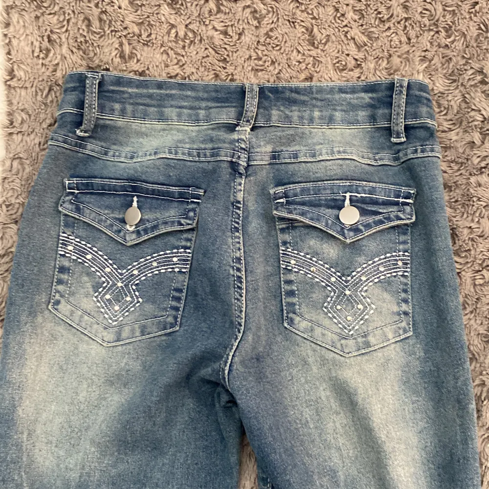 Ett par jeans med glitter på bakfickorna. Dessa är mörkblå och är i jätte bra skick då de bara har används en gång🩷. Jeans & Byxor.