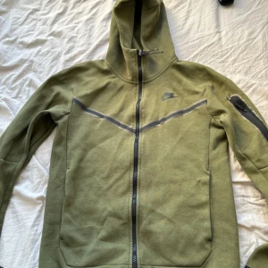 Nike tech grön - Nike tech grön! Plasten är lite sliten därför säljs den så billigt!