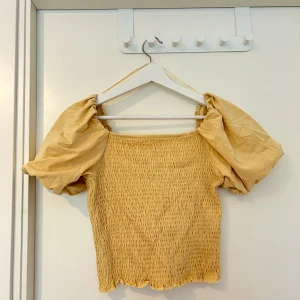 Gul topp med puffärm från GinaTricot  - En fin gul smockad topp med puffärm 💛 Storlek: L