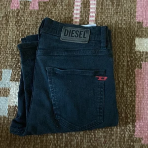 Svarta diesel jeans - Ett par riktigt snygga och unika jeans från märket diesel. Byxorna sitter sjukt skönt när de väl är på. De är en aning större i storleken. Byxornas skick är ungefär 8/10. Nån enstaka defekt men annars ser de som nya ut! Skriv vid frågor.
