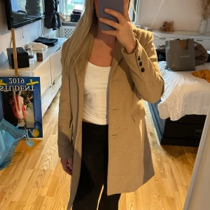 Kappa - Säljer denna kappa från ellos jag inte har använt. Den är i storlek 38. Den är beige/brun. 
