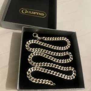 Silverkedja - Halsband av äkta silver. Mycket bra skick, har inga tecken på slitage om du inte kollar igenom ett förstoringsglas. Köpt på guldfynd för 1300. Boxen följer med. Väger 35 gram 6 mm bred 50 cm lång 2mm höjd. Hesitera inte på att skriva vid funderingar😁