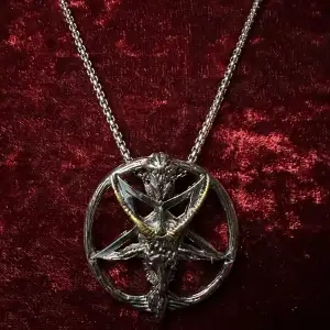 Nytt halsband i rostfritt stål med amulett med ockult motiv.  Pentagram i silver och guld i form av Baphomet, ibland kallad bockguden från Mendez. Amuletten är cirka 5 cm lång och 4 cm bred. Ormkedjan är 60 cm & har hummerlås.  Nytt och oanvänt.