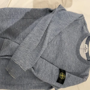 Stone island tröja - Riktigt snygg stone island tröja! Köpt på NK Stockholm, köpt för 1600kr. Skick 6-10, enbart lite sliten längst ner i ena ärmen. Inga andra defekter. Storlek 10Y, 142 cm