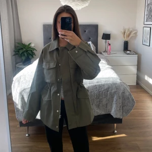 Grön jacka - Jacka från other stories! Superfint skick och inga defekter, tror nypris var ca 1500.  Den har dragsko i midjan så man kan justera om man vill ha den indragen eller inte! Jättefin jacka till våren men jag får ej användning av den tyvärr  Jag är 171