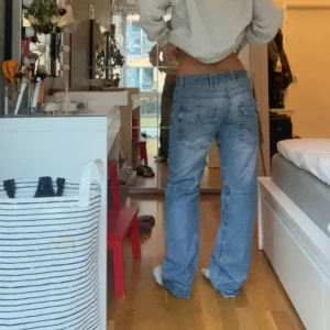 Coola baggy jeans - Ett par coola vida byxor med raka ben och låg midja köpa second hand. Knappar på bakfickorna. Hör av dig vid fler frågor🩷