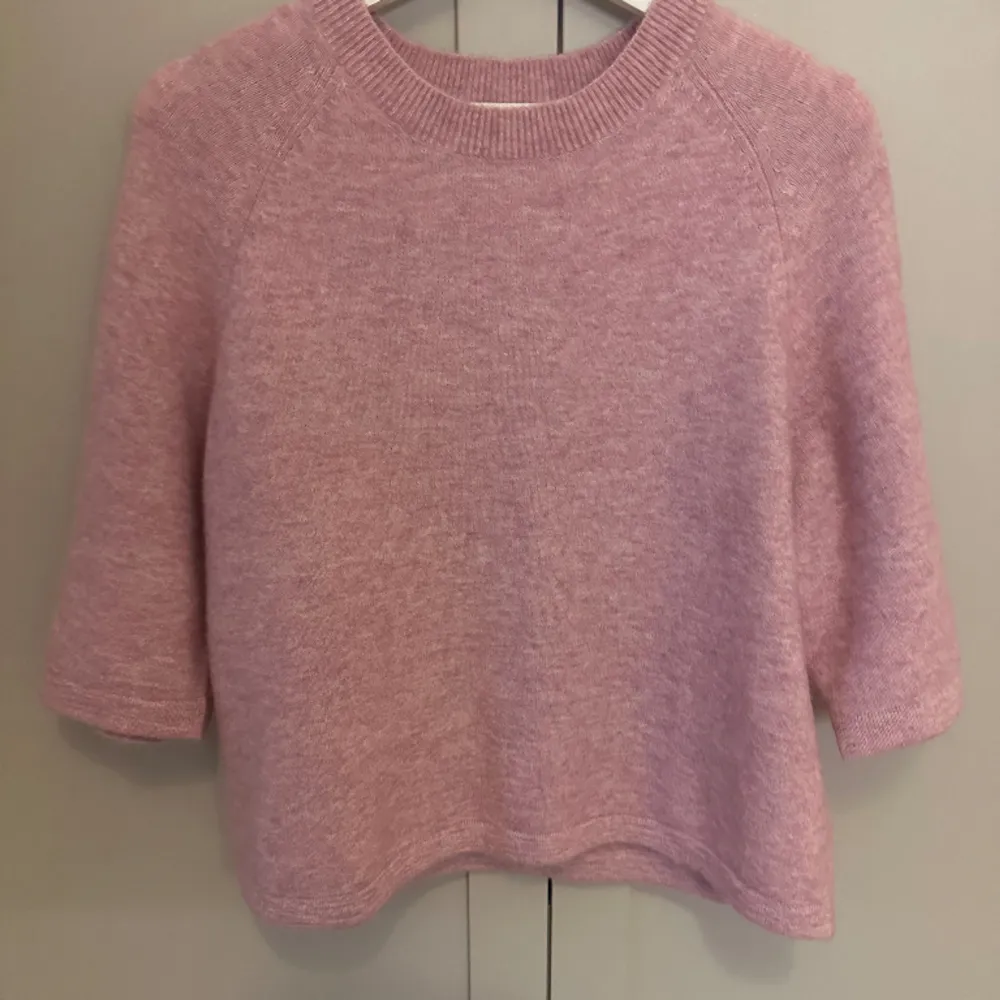 Kortärmad alpacka stickad tröja från &otherstories i så fin rosa färg. Nästan alldrig använd så den är som ny. Perfekt till vår och sommar😇. Stickat.