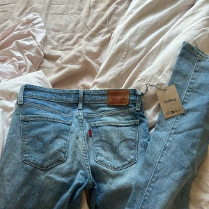 Levis Jeans - Säljer dessa fina blåa lågmidjade bootcut Levis jeans i storlek 24 som motsvarar XS/S, de är helt nya från Sellpy och har en liten defekt som syns på tredje bilden 💕Pris kan diskuteras 