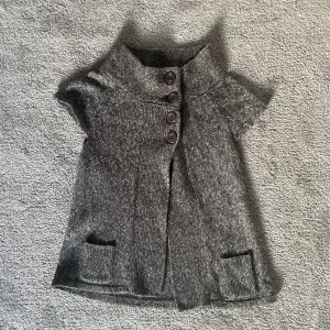 Kortärmad stickad kofta - En mycket söt stickad kofta från kappahl! Den är i mycket bra skick och är kortärmad i färgen grå💞 Skriv om ni är intresseradeeller har frågor🥰