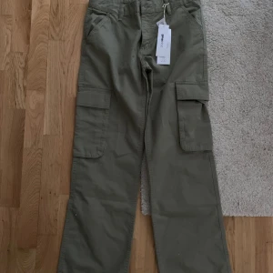Low waist cargo jeans - Jeansen är helt nya med prislapp! De är inte använda och de har en rak passform med storleken 36. Jag köpte de för 500kr men kommer sälja de för 150kr, priset kan dock diskuteras! Byxorna är i färgen ”khaki” (grön) och kan inte hittas i butik. 