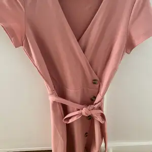 Rosa klänning med knappar på sidan strl s från Bubbleroom. Använd vid ett tillfälle. Pris 100kr