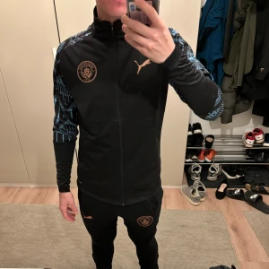 Manchester City Tracksuit - Typ helt oanvänd Man City tracksuit (finns tillhörande byxor). Den har bara hängt på väggen nu i två år. Har vuxit ur den för länge sedan. 