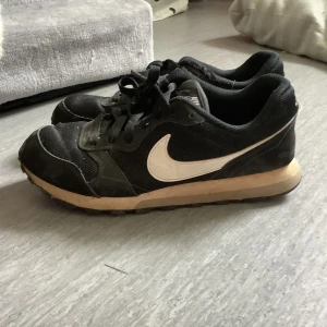 Snygga Nike skor (new Balance liknade)  - Fina skor från Nike svartvita i strl 36,5 i använt skick