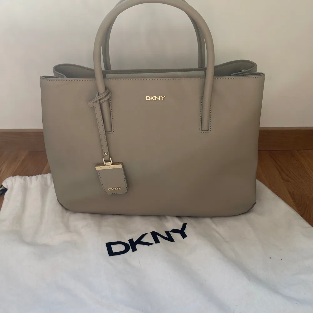 DKNY Väska som är använd 1-2 ggr Max, så i ny skick.  Ganska stor och rymlig, skrivblock och dator får gott plats. . Väskor.