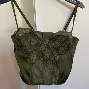 Grön korsettopp - Superfin korsettopp köpt här på Plick, bild 3 och 4 är lånade. Säljes vidare då den var för lös på mig. Passar a-b kupa. Fint skick! Kontakta mig innan ni använder köp nu<3
