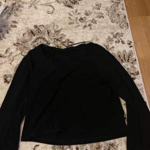 En svart tröja med volang armar 