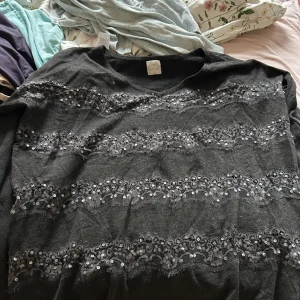 Stickad tröja med pasteller på i grå och svart  - Stickad tröja, storlek s/m, pösig, lång i ärmarna