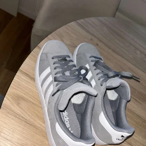 Adidas campus 2 - Säljer mina skor som är använda en enda gång utomhus. Jag säljer dessa för att jag märke att storleken var lite för liten för mig. Skulle säga att de är mer som en 39/40🩷 Storlek: 40 Färg: Grå Inköpta för 1300kr Inga defekter osv, inprincip orörda 