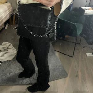 Handväska  - Svart handväska med silver band. Andvänd få gånger. Skriv om ni vill ha bilder på insidan. Inte äkta Stella McCartney väska!! Pris kan diskuteras!