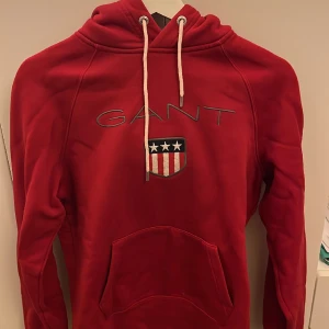 Röd GANT Hoodie - Tja, säljer min röda Gant hoodie som jag bara använt några gånger. Det är i bra skick och är storlek S Pris kan diskuteras