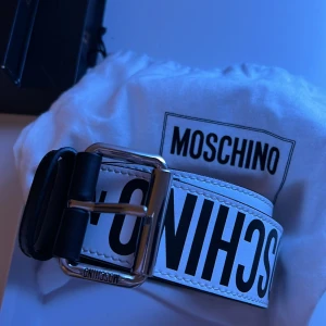Mochino bälte - Helt nytt mochino bälte som är i 10/10 skick. ÄKTA så klart. Bara att höra av er om ni undrar nåt. Nypris 2.400kr