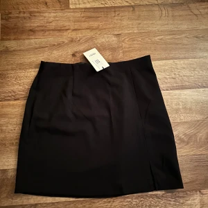 Kjol slits - Kjol från Nelly, men märket är ”Object”. Kjolen är svart och har slits, aldrig använd prislappen kvar. Jättefin, men tyvärr för stor för mig. Den har även dragkedja.