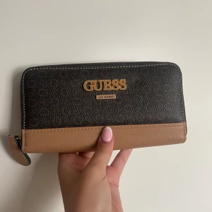 Guess plånbok - Helt ny (den kom med en liten liten skråma på baksidan). Pär plats med mycket, till och med mobilen.