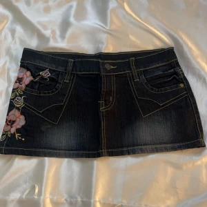 Lågmidjad jeanskjol  - Säljer min vintage lågmidjade jeanskjol, rätt så kort men jätte fin till sommaren, med ett litet blommönster längst högra sidan💗 38 cm tvärsöver midjan, 24 cm lång på framsidan, 26 cm lång på baksidan, tryck gärna köp nu eller kom privat för frågor💖🌟