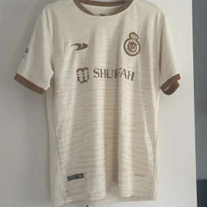 Al nassr fotbollströja - Al nassr tröja i ett 10/10 skick då den ör använd fåtal gånger men är lite stor för mig. Kom t mig vid frågor eller funderingar🤝
